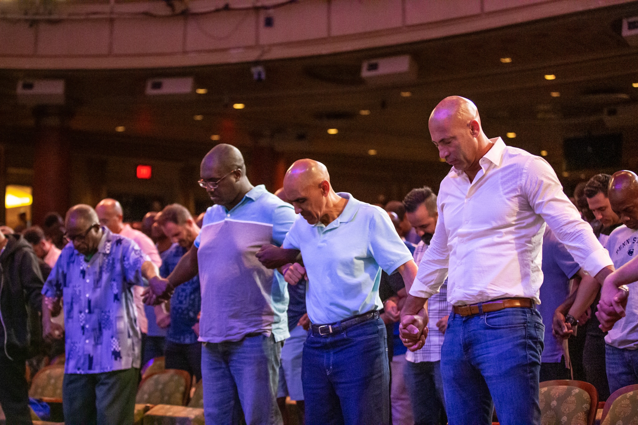 Men holding hands praying