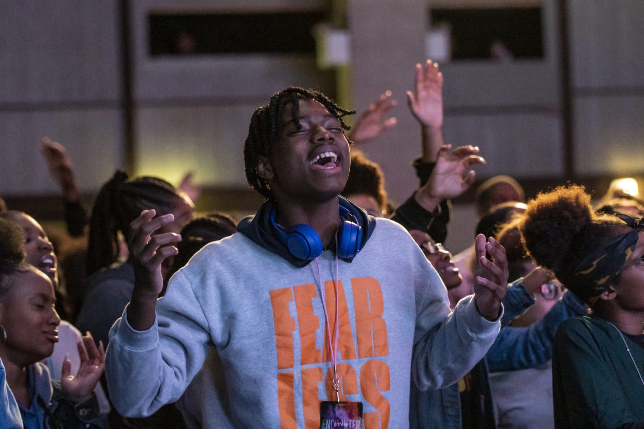 Boy with blue headphones on the neck praising