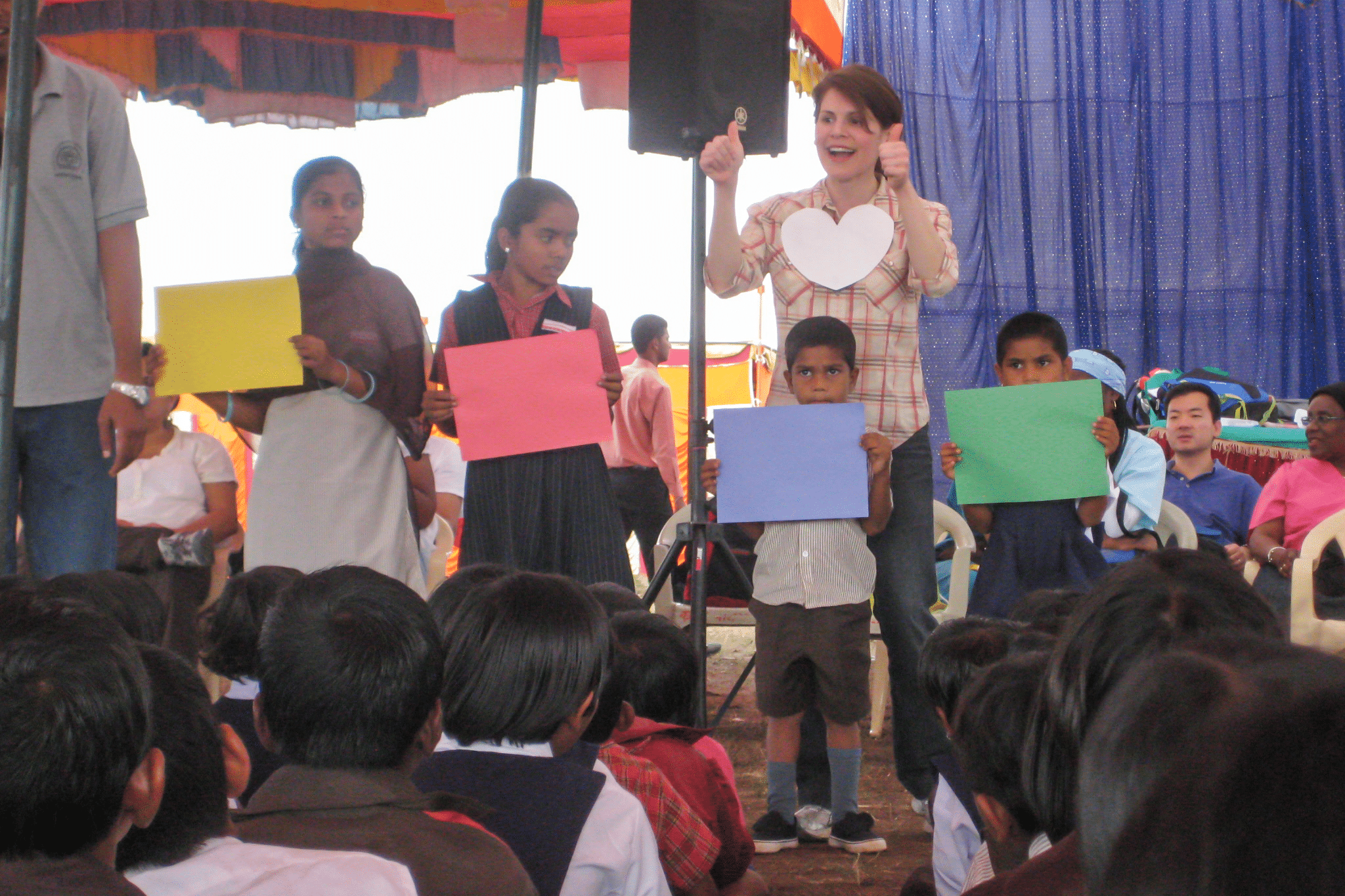 kids on stage performing, woman thumbs ups