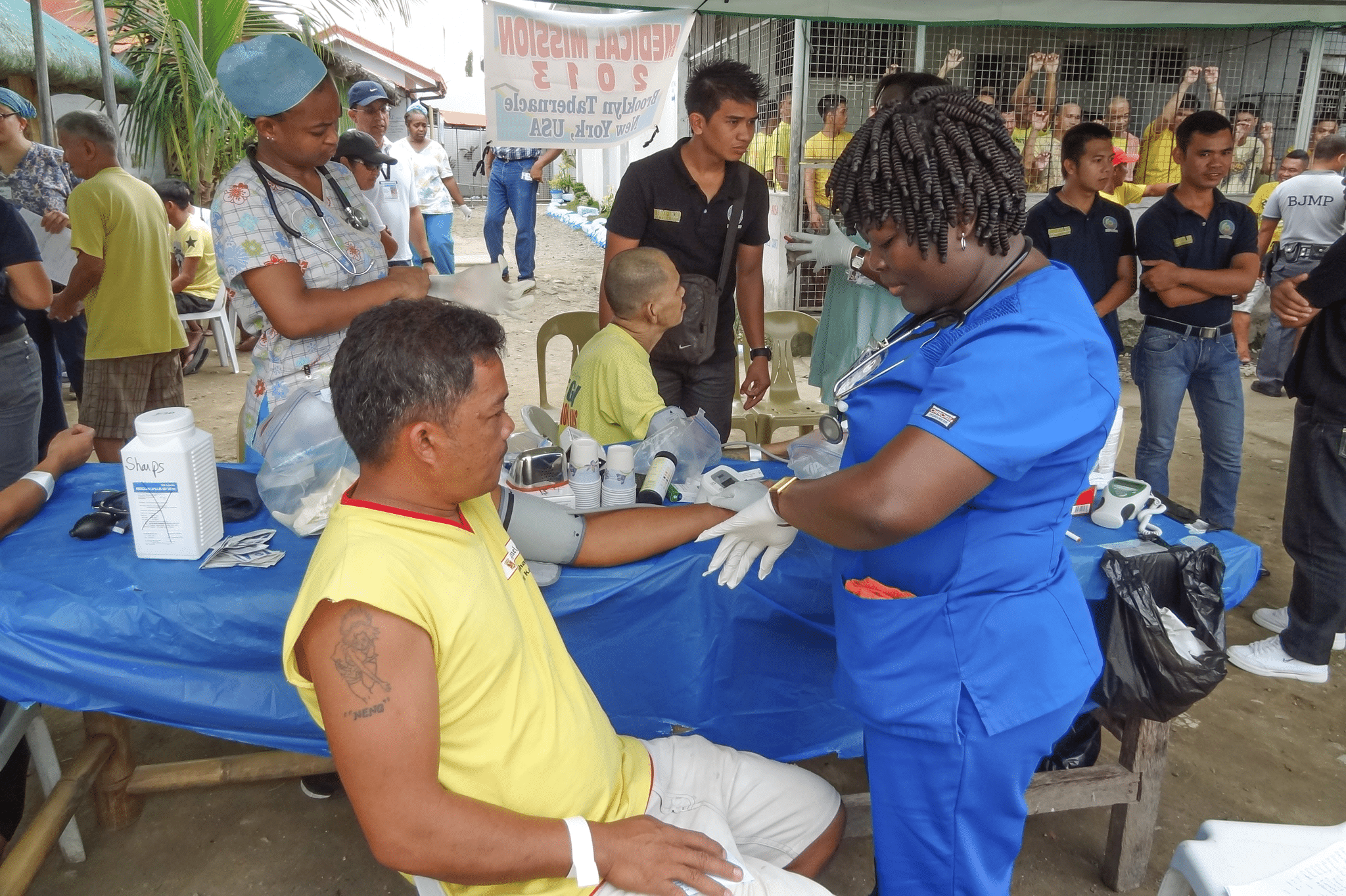 Nurse checking man's blood pressure, community medical outreach