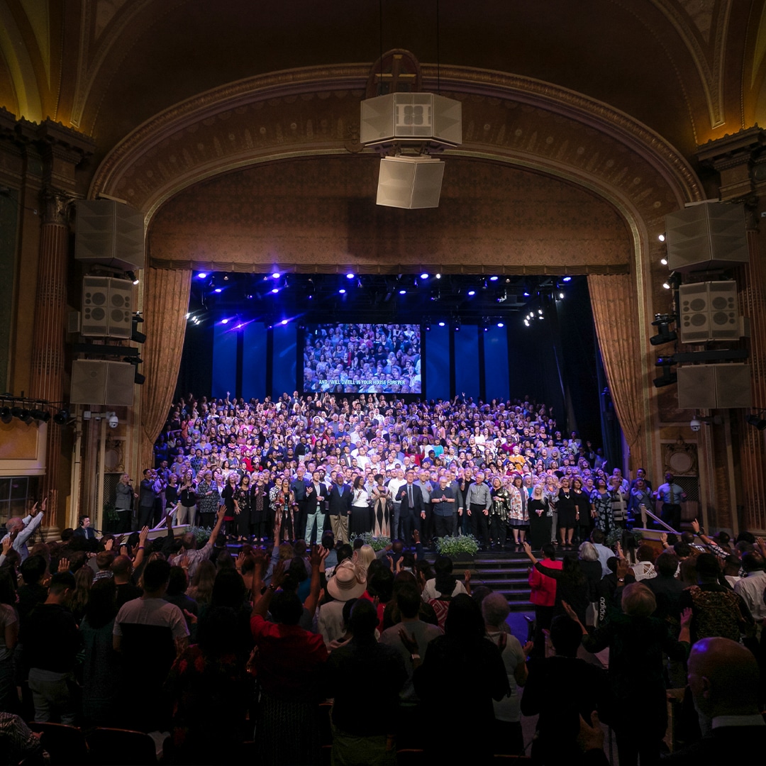 Brooklyn Tabernacle Choir singing on stage with Pastor Jim and Carol Cymbala in sanctuary with audience worshipping