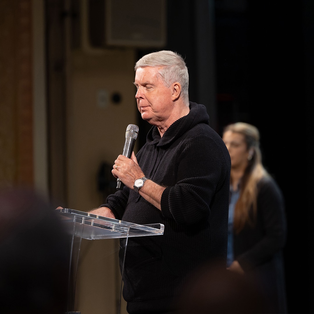 close up of Pastor Jim Cymbala standing with microphone in front of pulpit