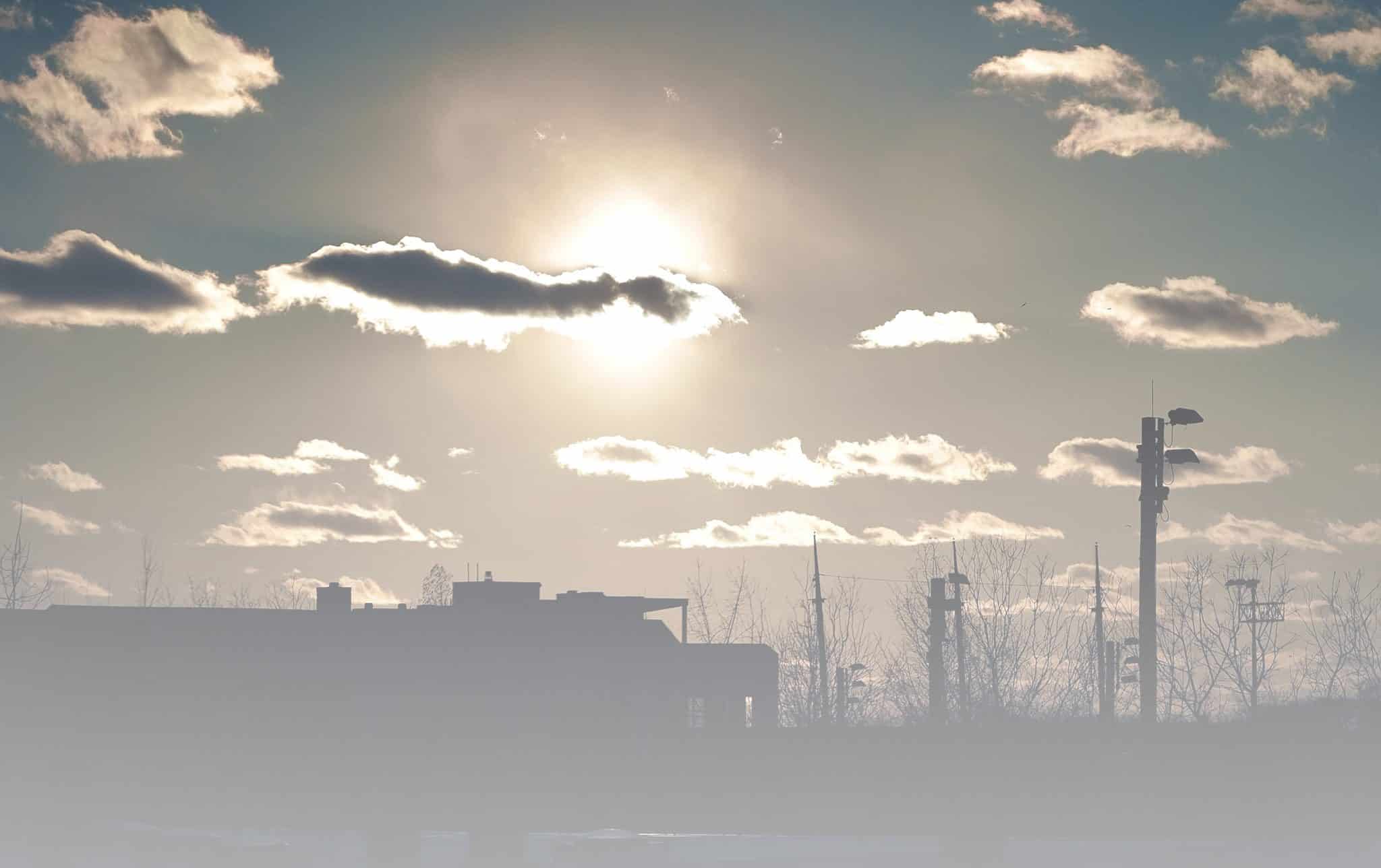 Sunlight shining out from behind clouds in city