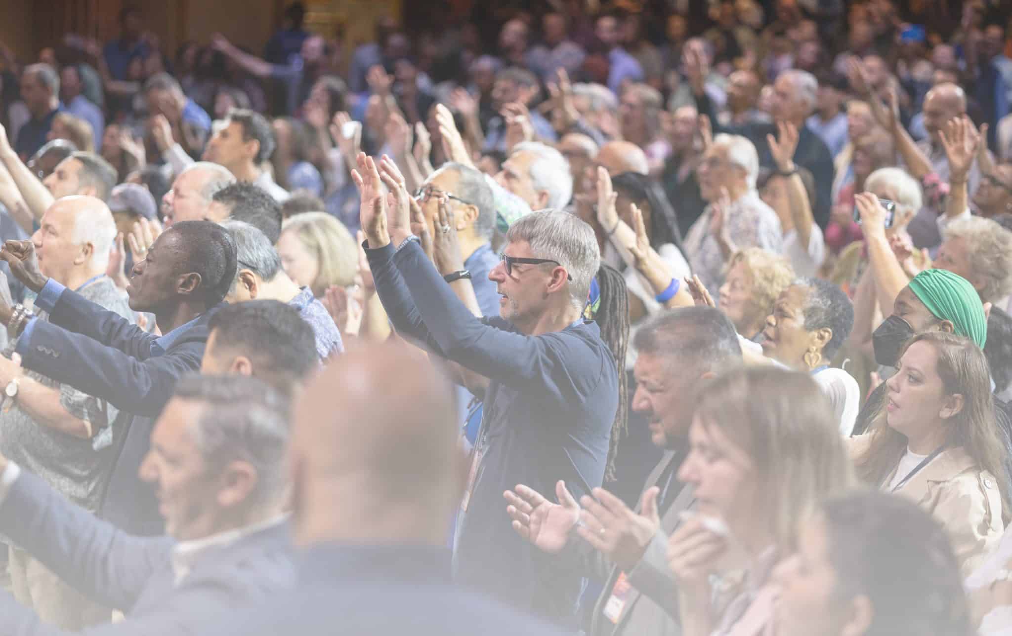 A diverse group of people from many churches singing praise to God.