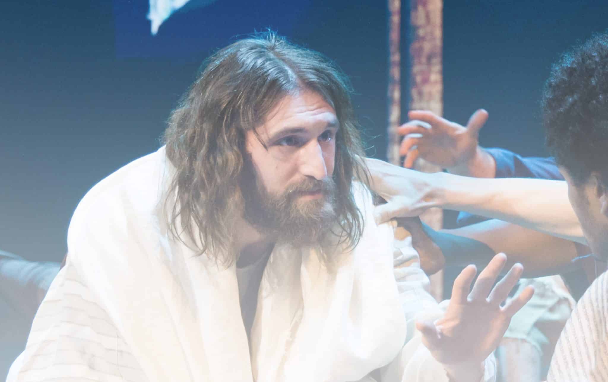 An actor playing Jesus looks with compassion and kindness at a person