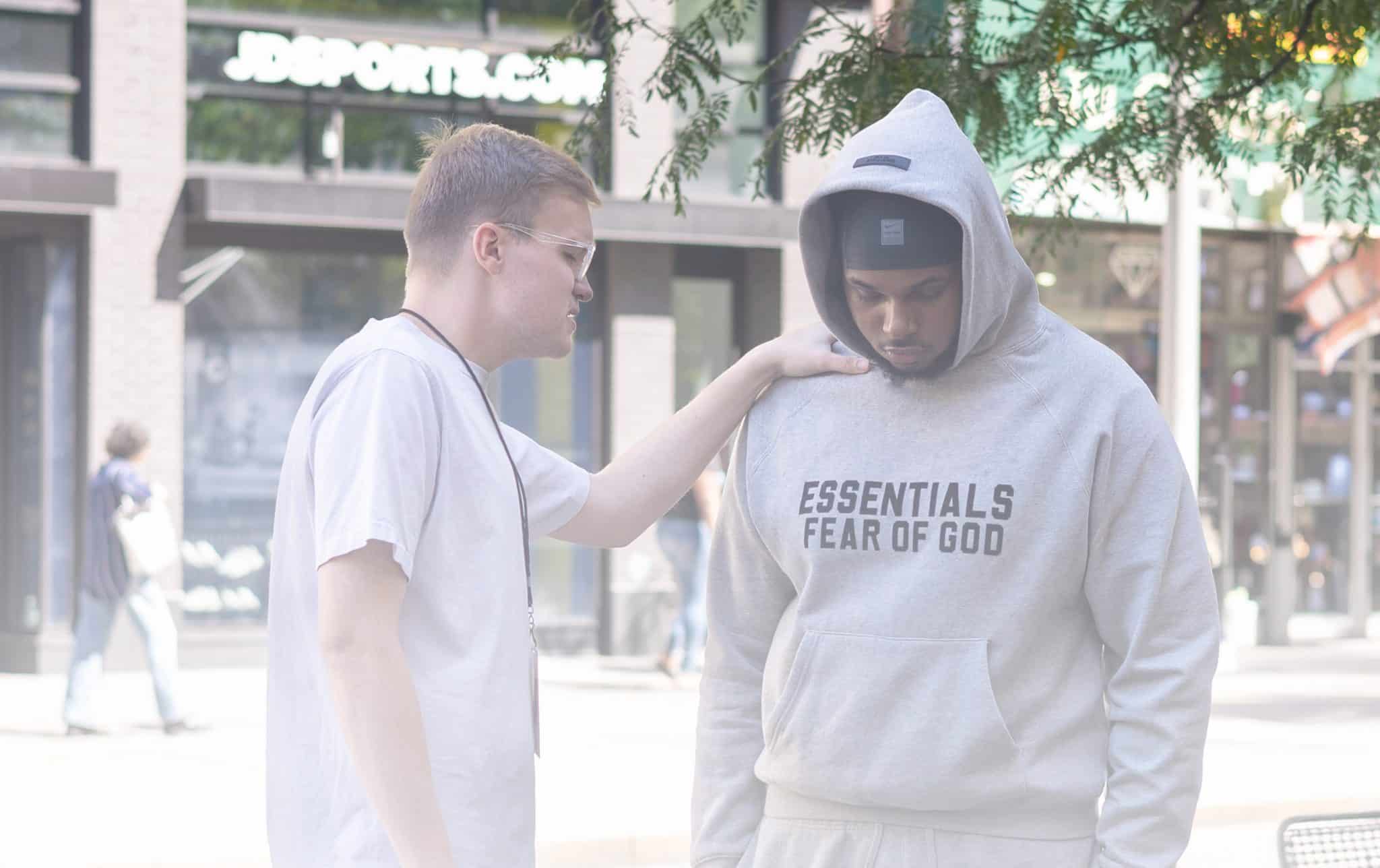 A man praying over someone after sharing the gospel.